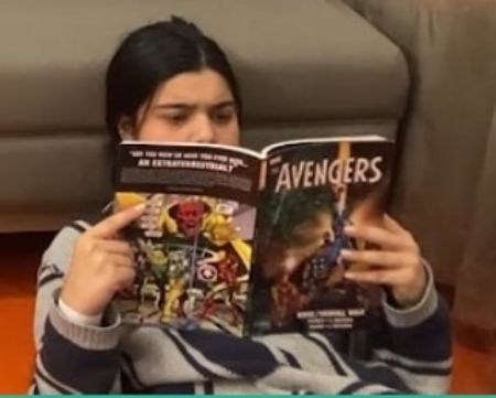 A young Iman Vellani reading Marvel Comics